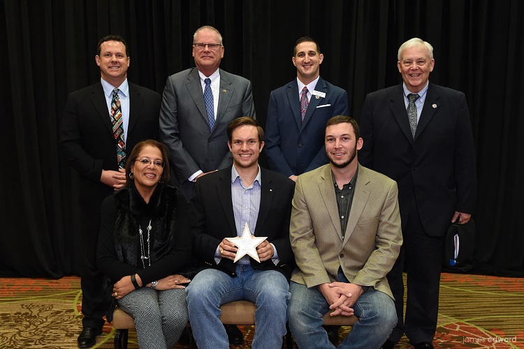 Group of men in business attire holding a star award.