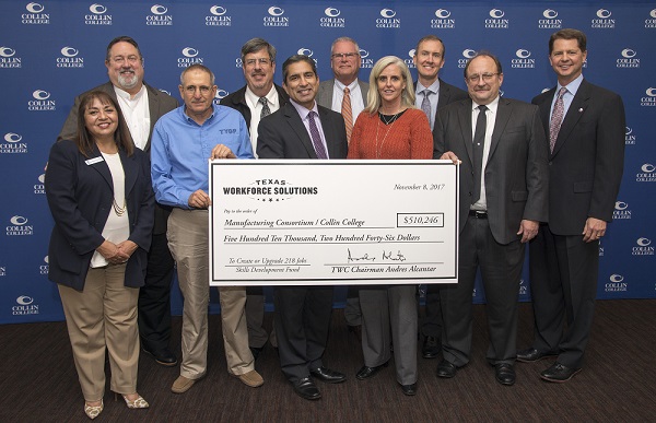 Group of folks in business attire holding a large check from Workforce Solutions.